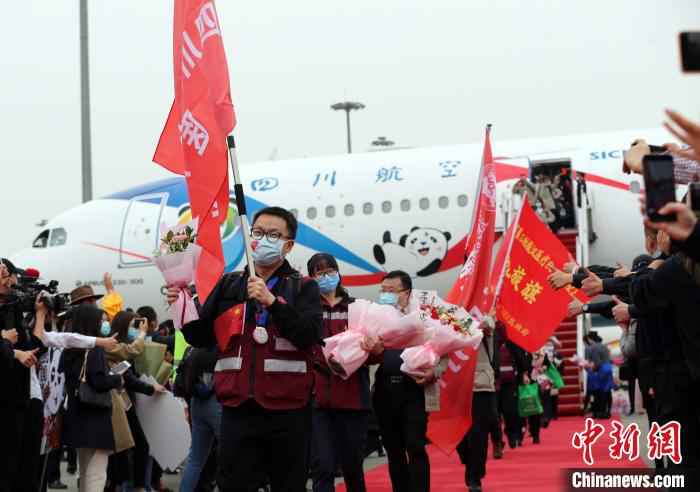 机舱打开,医护人员走下飞机。 王磊 摄 最后一批援湖北“白衣川军”归家:“一个都没有少”